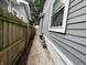 Narrow side yard with a concrete walkway and a wood fence leading to the backyard at 2918 Ruckle St, Indianapolis, IN 46205