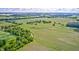 Expansive aerial view of lush, green agricultural land interspersed with wooded areas and scattered homes, under a partly cloudy sky at 303 E County Road 500 N, Pittsboro, IN 46167