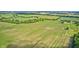Lush farmland and distant residences viewed from above, bordered by treelines and open fields, under a clear, expansive sky at 303 E County Road 500 N, Pittsboro, IN 46167