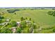 Aerial view of home and surrounding farmland with outbuildings and mature trees at 303 E County Road 500 N, Pittsboro, IN 46167