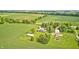 Aerial view of the residence surrounded by green lawn and farmland at 303 E County Road 500 N, Pittsboro, IN 46167