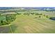 Overhead angle of verdant farmland and sparse clusters of trees, blending to the far horizon under the clear expanse of the sky at 303 E County Road 500 N, Pittsboro, IN 46167
