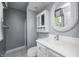 Well-lit bathroom with a white vanity, decorative mirror, and shower with glass doors at 303 E County Road 500 N, Pittsboro, IN 46167