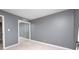 This empty bedroom offers gray walls, light floors, and a mirrored closet to personalize as your own at 303 E County Road 500 N, Pittsboro, IN 46167