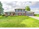 Charming two-story brick home with well-manicured lawn, flower beds, and an attached two car garage at 303 E County Road 500 N, Pittsboro, IN 46167