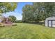 Expansive backyard with lush lawn, mature trees, a storage shed, and a deck at 360 Myers Lake Dr, Noblesville, IN 46062