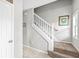 Hallway features staircase with carpet steps, white railing, neutral walls, and ceramic tile flooring at 360 Myers Lake Dr, Noblesville, IN 46062