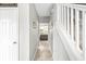 Hallway with tiled floor leads to the kitchen, featuring a staircase and neutral decor at 360 Myers Lake Dr, Noblesville, IN 46062
