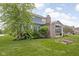 Picturesque backyard with a covered patio, established trees, and neatly landscaped garden beds at 3720 Abney Highland Dr, Zionsville, IN 46077