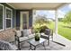 Relaxing covered patio with brick accents, comfortable seating, and views of the expansive lawn at 3720 Abney Highland Dr, Zionsville, IN 46077