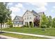 Beautiful two-story home with a stone and siding exterior, manicured lawn, and mature trees at 3720 Abney Highland Dr, Zionsville, IN 46077