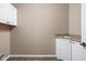 Bright laundry room features a sink, cabinet storage, and tile flooring at 3720 Abney Highland Dr, Zionsville, IN 46077