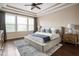 Bright main bedroom showcasing a decorative tray ceiling, hardwood floors, and windows at 3720 Abney Highland Dr, Zionsville, IN 46077