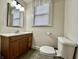 Bathroom featuring a toilet, oak sink, mirror, light fixtures and window at 388 N Ohio St, Martinsville, IN 46151