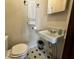Cozy bathroom featuring a toilet, a sink, black and white tiled floor and an elevated soap tray at 388 N Ohio St, Martinsville, IN 46151