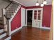 Dining room featuring hardwood floors, red paint, and a stairway at 414 E Main St, Plainfield, IN 46168