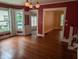 Dining room featuring hardwood floors, red paint, windows, and light fixtures at 414 E Main St, Plainfield, IN 46168