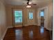 Empty living room with hardwood floors, windows, sliding doors, and neutral colors at 414 E Main St, Plainfield, IN 46168