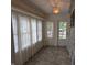 Bright sunroom featuring tiled floors, sheer curtains, and a star-shaped pendant light fixture at 414 E Main St, Plainfield, IN 46168