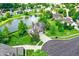 Overhead view of a beautiful brick home in a serene neighborhood, complete with a backyard pond and lush greenery at 4279 Redwood Ct, Zionsville, IN 46077