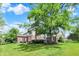 Expansive backyard features a brick home, lush lawn, and mature trees, perfect for outdoor activities and relaxation at 4279 Redwood Ct, Zionsville, IN 46077
