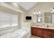 Bathroom with a soaking tub, double vanities, and natural light from the window at 4279 Redwood Ct, Zionsville, IN 46077