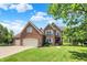 Beautiful brick two-story home featuring a manicured lawn, mature trees, and a three-car garage at 4279 Redwood Ct, Zionsville, IN 46077