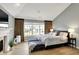 Main bedroom with vaulted ceiling, large bed, hardwood floors, and fireplace at 4279 Redwood Ct, Zionsville, IN 46077