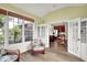 Bright sunroom featuring large windows, hardwood floors, and double doors leading into the kitchen at 4279 Redwood Ct, Zionsville, IN 46077