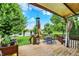 Cozy back deck with a serene view of the backyard featuring a table, lush lawn, and pond at 564 Gainesway N Dr, Greenwood, IN 46142