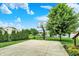 Green backyard features a basketball court near a lake, offering scenic views and space for recreational activities at 564 Gainesway N Dr, Greenwood, IN 46142