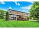 Spacious backyard featuring a two-story home, deck, green lawn, and mature trees for outdoor living and recreation at 564 Gainesway N Dr, Greenwood, IN 46142