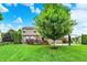 Landscaped backyard with a spacious lawn, deck, and mature tree, offering a serene outdoor space for relaxation and entertainment at 564 Gainesway N Dr, Greenwood, IN 46142