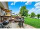 Backyard view highlighting the lush lawn, mature trees, patio with a grill, and a view of the pond at 564 Gainesway N Dr, Greenwood, IN 46142