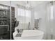 Bright bathroom with a modern tub, chandelier, and wood-accented glass shower at 564 Gainesway N Dr, Greenwood, IN 46142