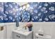 Stylish powder room with blue wallpaper, vanity sink, and a modern mirror at 564 Gainesway N Dr, Greenwood, IN 46142