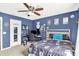 Bedroom features a ceiling fan, blue walls, and desk with computer at 564 Gainesway N Dr, Greenwood, IN 46142