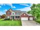 Charming two-story brick home with a well-manicured lawn and a three car attached garage at 564 Gainesway N Dr, Greenwood, IN 46142