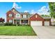 Charming two-story brick home with a well-manicured lawn, beautiful landscaping, and a three car attached garage at 564 Gainesway N Dr, Greenwood, IN 46142