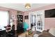 Comfortable home office with desk, chair, bookshelf, and a view into the playroom at 564 Gainesway N Dr, Greenwood, IN 46142