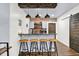 Stylish basement wet bar with seating, brick backsplash, and shiplap accents at 564 Gainesway N Dr, Greenwood, IN 46142