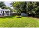 Spacious backyard with a deck, fire pit, shed, and mature trees at 5736 Primrose Ave, Indianapolis, IN 46220
