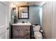 Charming bathroom with modern vanity, wood-framed mirror, and a toilet with a striped shower curtain at 5736 Primrose Ave, Indianapolis, IN 46220