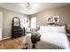 Bright bedroom features a queen bed, hardwood floors, neutral walls, two windows, and black furniture at 5736 Primrose Ave, Indianapolis, IN 46220