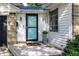 Close up of the front door and porch of a well-maintained home, with blue accents and a decorative flower pot at 5736 Primrose Ave, Indianapolis, IN 46220