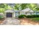 Charming single-story home featuring stone and white siding, black garage door, and neat landscaping at 5736 Primrose Ave, Indianapolis, IN 46220