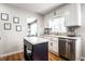 Well lit kitchen with white cabinets, an island, stainless steel appliances, and wood flooring at 5736 Primrose Ave, Indianapolis, IN 46220