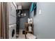 Functional laundry room with stacked washer and dryer, shelving, and storage space for laundry supplies at 5736 Primrose Ave, Indianapolis, IN 46220