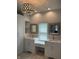 Bathroom with double sinks, updated cabinetry, granite countertops, a chandelier, and natural light at 5775 Coopers Hawk Dr, Carmel, IN 46033