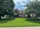 Charming brick home with a well-manicured lawn and mature trees at 5775 Coopers Hawk Dr, Carmel, IN 46033